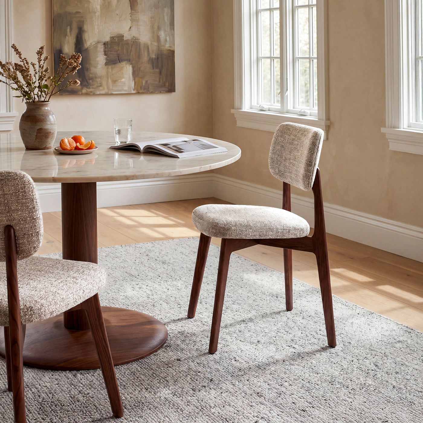 Curved upholstered dining chairs paired with a round pedestal table