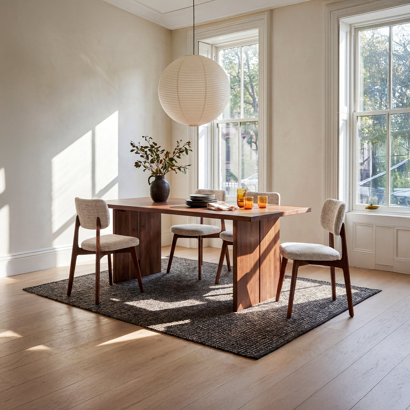 Upholstered walnut dining chairs with a wooden table rug and pendant light