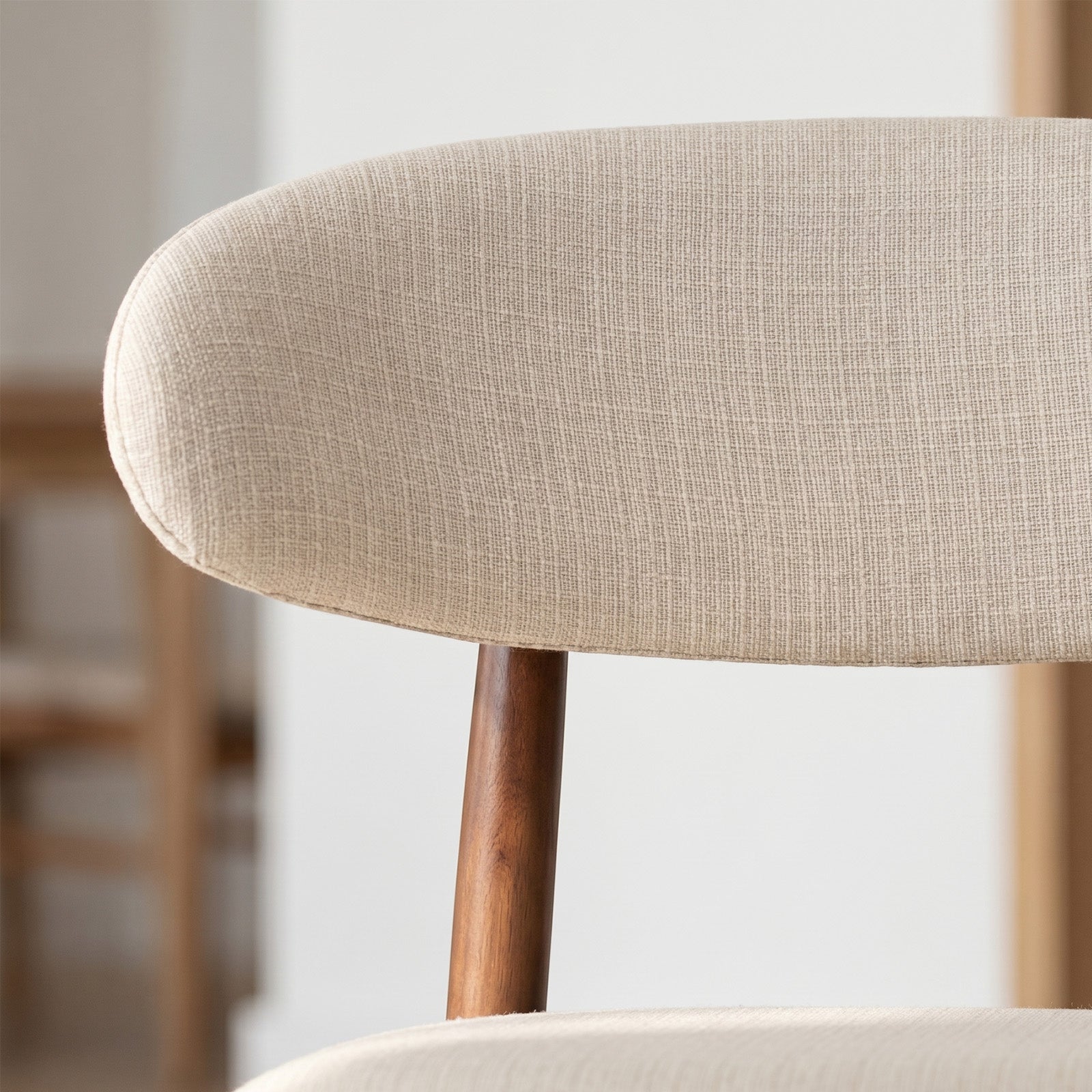 Close-up of COLAMY ARLA beige fabric counter stool backrest with wooden support