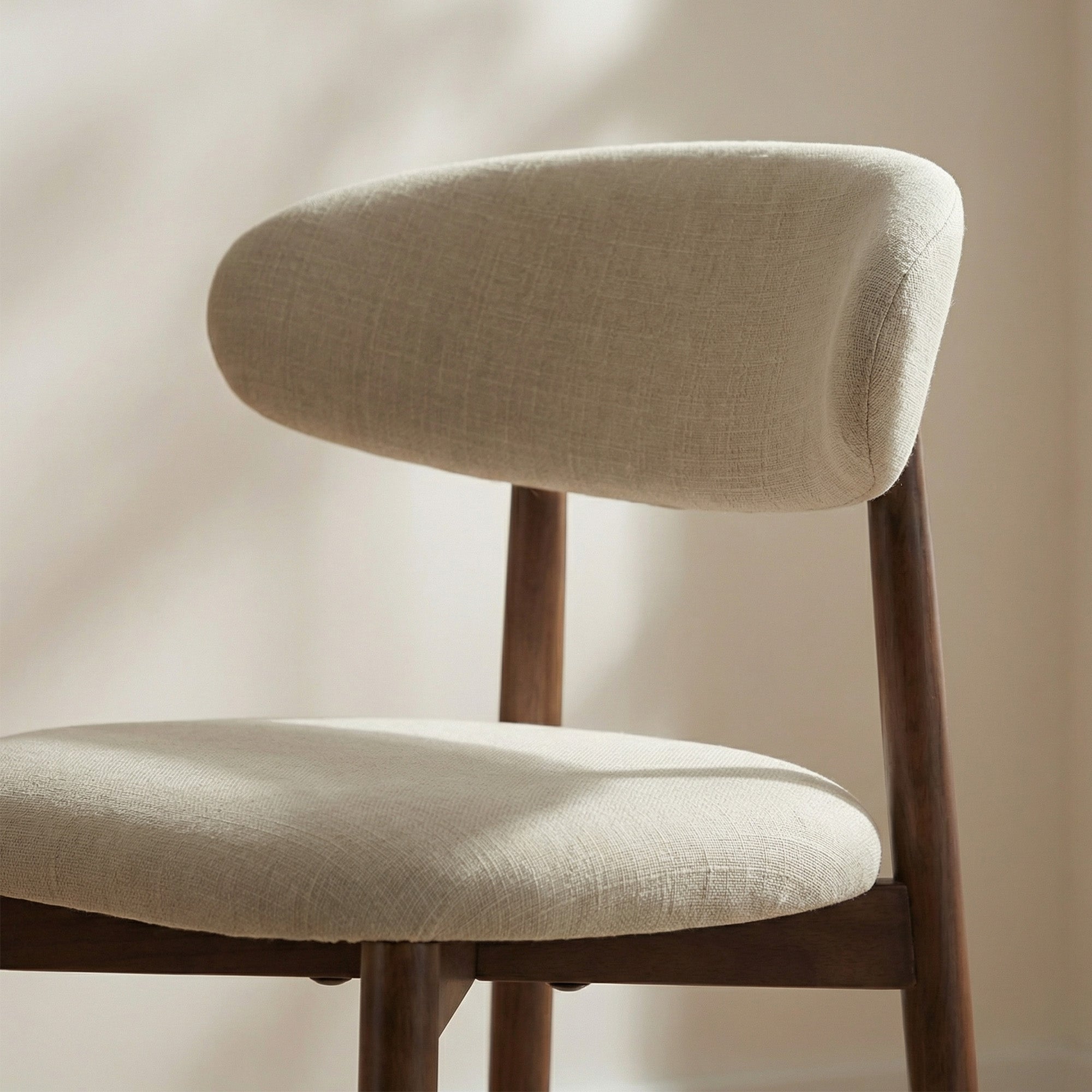 Close-up of COLAMY ARLA beige upholstered counter stool with curved backrest and padded seat