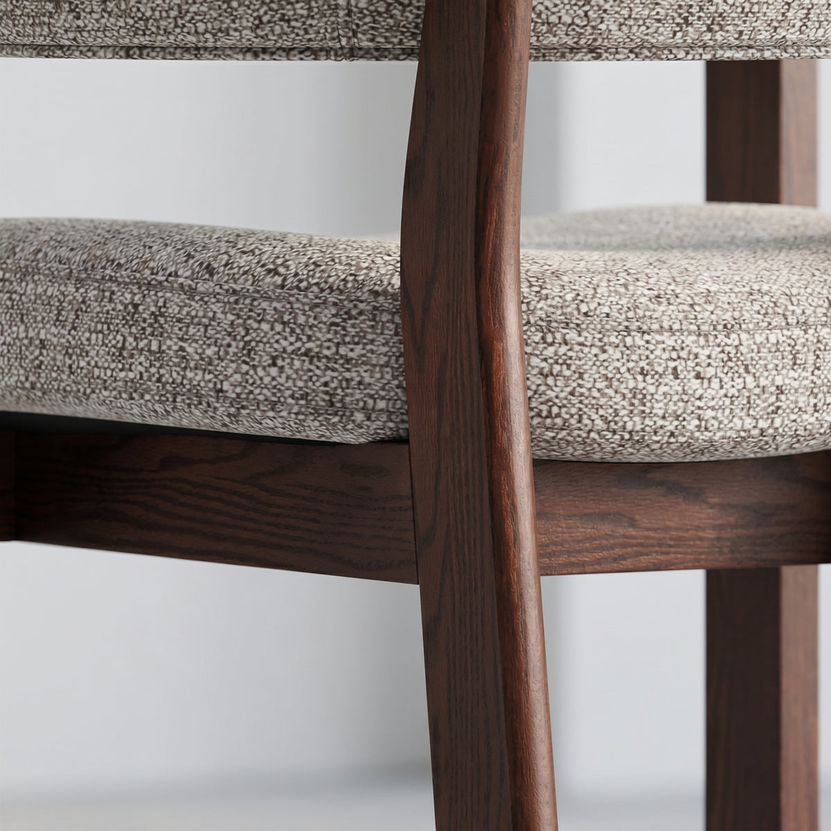 Close-up of the dark solid oak frame and textured upholstery on the Halo Luxe dining chair